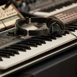 A pair of headphones lying on top of a keyboard.