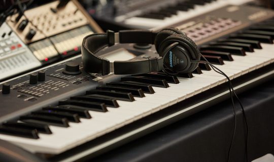 A pair of headphones lying on top of a keyboard.