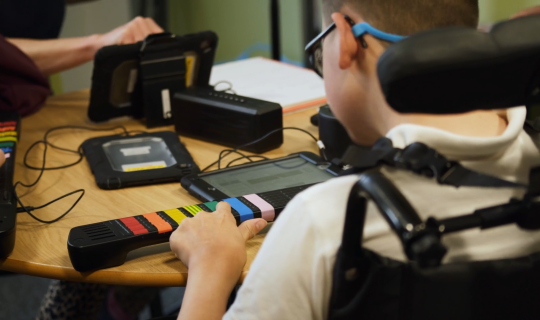 a child playing a digital instrument with buttons
