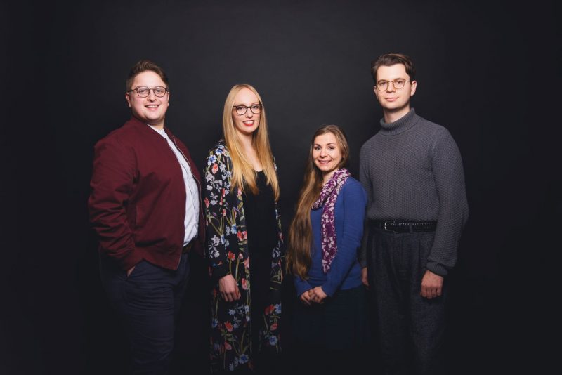 Four young composers stand in a row