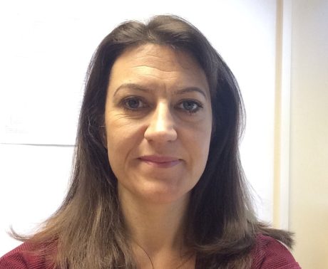 Charlotte Payne facing the camera. She has shoulder-length brown hair and is wearing a burgundy t-shirt.