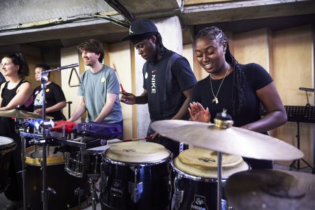 A photo of young adults playing percussion.