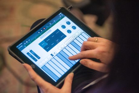 a hand uses music education software on an Apple iPad