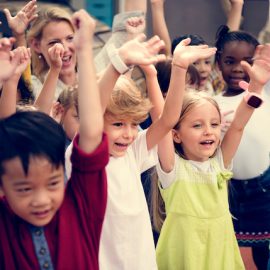 A group of children with their arms raised up in the air