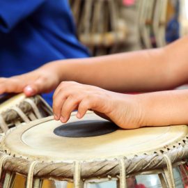 Two hands playing drums.